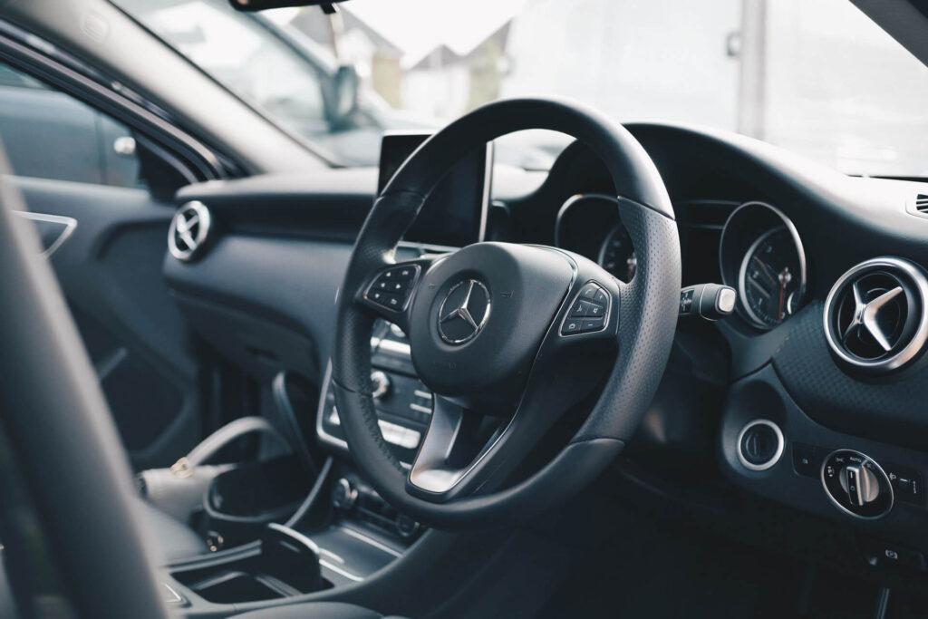 inside of a clean mercedes with dark steering wheel